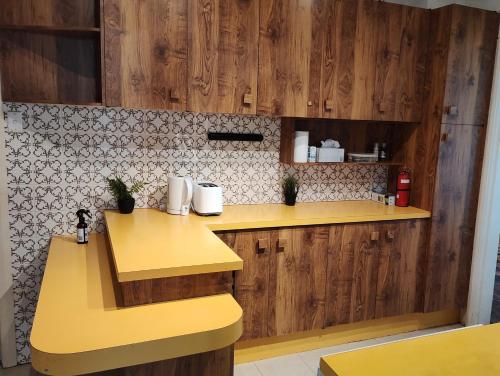 堪培拉Private separate unit - A in O'Connor的厨房设有黄色柜台和木制橱柜。