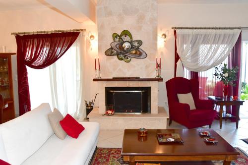 阿吉亚玛丽娜Sanctuary Villa in Vagia, Aegina的客厅配有白色沙发和壁炉