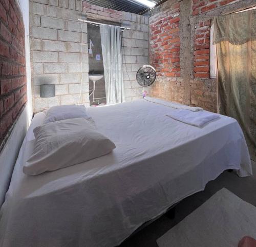 里瓦斯Hostal Brisas del Ometepe的卧室配有一张大白色的砖墙床