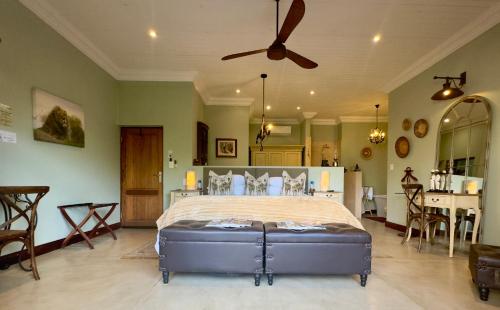 马里兰卡姆巴库河山林小屋的一间卧室配有一张大床和吊扇