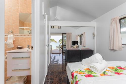 拉罗汤加贝拉海滩简易别墅酒店的一间卧室配有一张床,浴室设有水槽