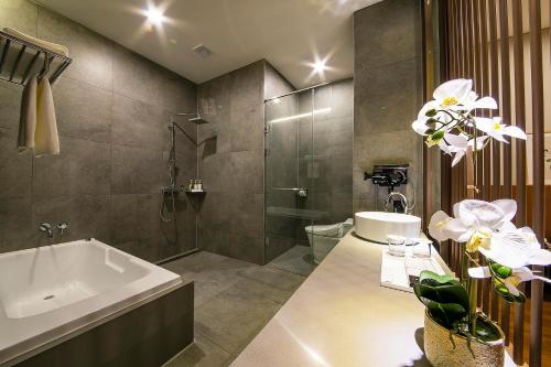 晋州市Epoche Hotel的带浴缸、淋浴和盥洗盆的浴室