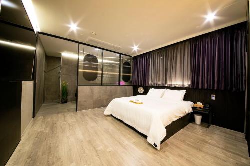 晋州市Epoche Hotel的卧室配有一张白色大床