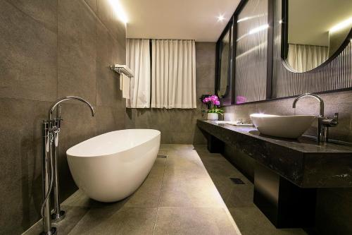 晋州市Epoche Hotel的一间带两个盥洗盆和大浴缸的浴室