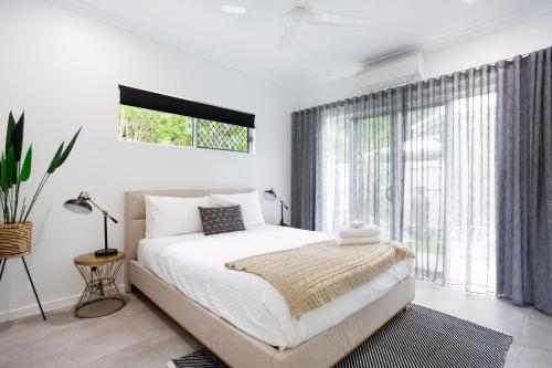 艾吉希尔Bamboo Villa - Pet friendly luxury Villa next to Botanical Gardens的一间卧室设有一张床和一个大窗户