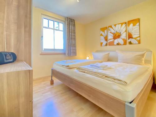 赛巴特班森Neue Villa Ernst - Ferienwohnung 4的卧室配有一张大白色床和窗户
