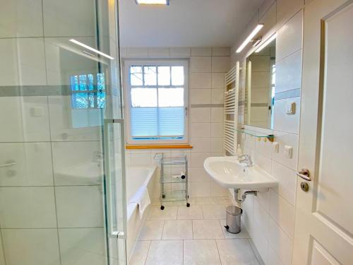 赛巴特班森Neue Villa Ernst - Ferienwohnung 4的白色的浴室设有水槽和淋浴。