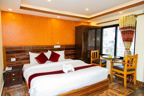 加德满都Hotel Everest Regency的卧室配有1张床、1张桌子和1把椅子