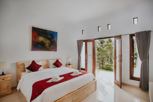 珀尼达岛De Casa Ananda Nusa Penida的一间卧室配有一张带红色枕头的大床