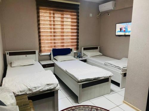 杜尚别ObodHotel的一间医院间,设有三张床和电视