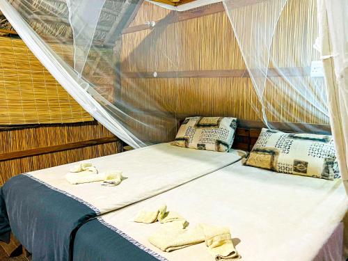 希登盖莱Nhambavale Lodge的船上的两张床铺,上面有毛巾