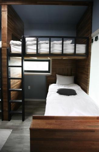 春川91 Stay的一间卧室设有两张双层床和梯子