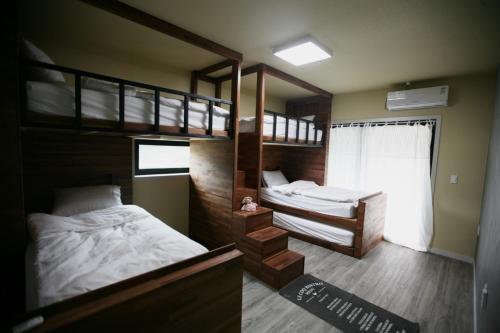 春川91 Stay的一间卧室设有两张双层床和一扇窗户。