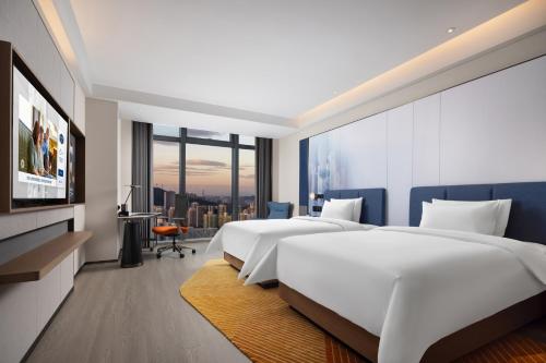 深圳深圳福田华强北希尔顿欢朋酒店的一间酒店客房,设有两张床和电视