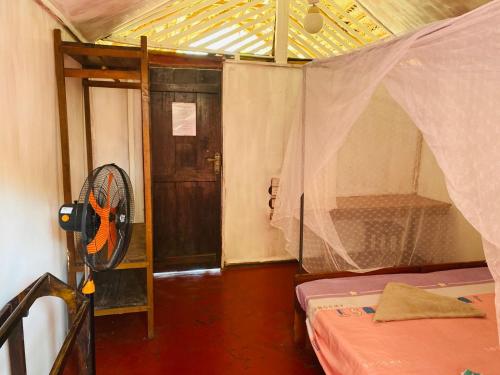 阿鲁甘湾Rainbow Village Cabanas的客房设有带风扇和门的房间。