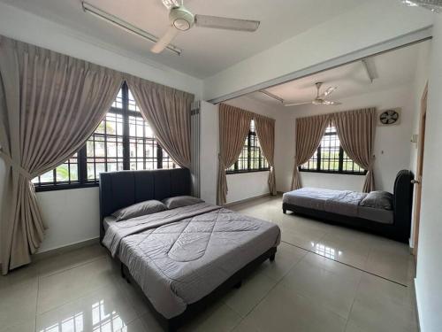 乌鲁地南Pelangi Indah 8 Rooms Corner Pool Table的一间卧室设有两张床和两个窗户。