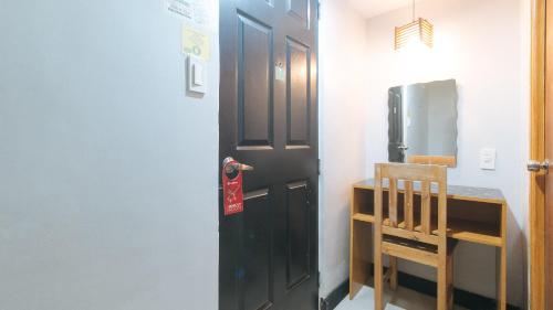 马尼拉RedDoorz at Ranchotel Alabang的带冰箱的厨房里的黑色门