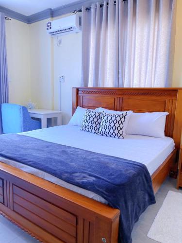 蒙巴萨Antlaya的一间卧室配有一张带蓝色毯子的木床