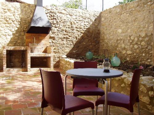 OrtellsApartamentos Bergantes的一个带桌椅和石墙的庭院