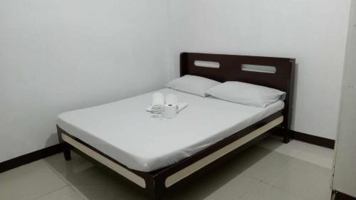 达沃市Sharana Pensionne的一张带白色床单和白色枕头的床