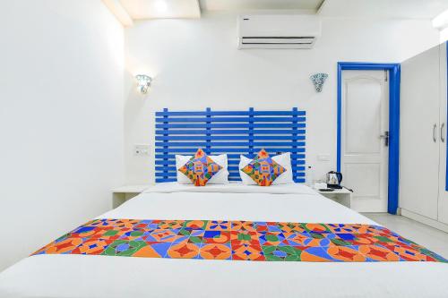 斋浦尔FabHotel Istana Inn的一间卧室配有一张带彩色毯子的床
