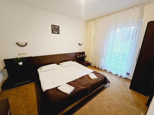 波亚纳布拉索夫VILA GALBENA - Poiana Brasov的一间卧室设有一张大床和一个大窗户