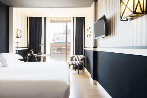 巴塞罗那欧洲公园酒店的一间酒店客房,配有一张床和一台电视