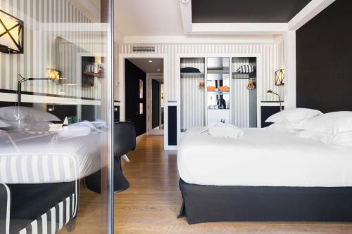 巴塞罗那欧洲公园酒店的一间卧室设有两张床和玻璃墙