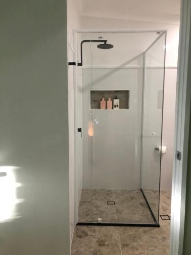 谭伯连山Tamborine Mountain Lodge的浴室里设有玻璃门淋浴