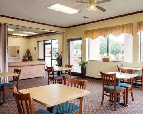格林伍德Rodeway Inn的用餐室配有桌椅和沙发