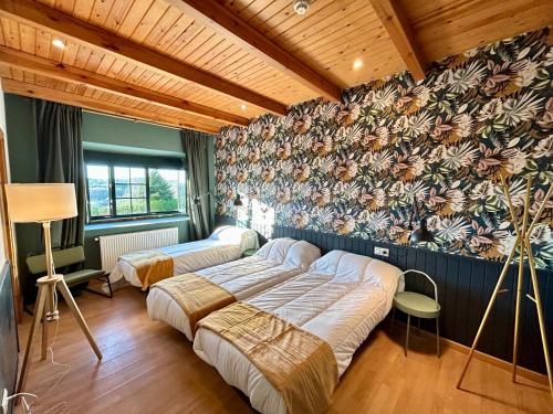 帕拉斯德丽Casa Bolboreta的卧室设有两张床铺和花卉墙