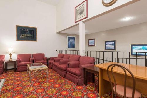 布里奇顿Quality Inn & Suites的一间设有红色椅子和桌子的等候室