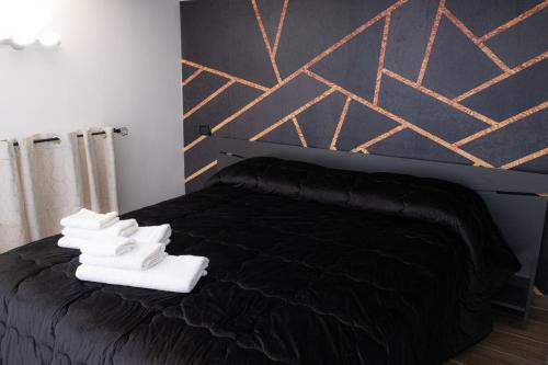 那不勒斯Napoli Center Suite Palmentieri的一间卧室配有黑色床和白色鞋