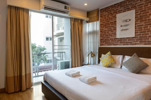 Klong ToiGO INN ThongLor的一间卧室设有一张大床和一个大窗户