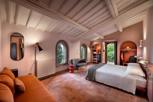潘札诺La Pensione di Vignamaggio的一间卧室配有一张大床和一张沙发