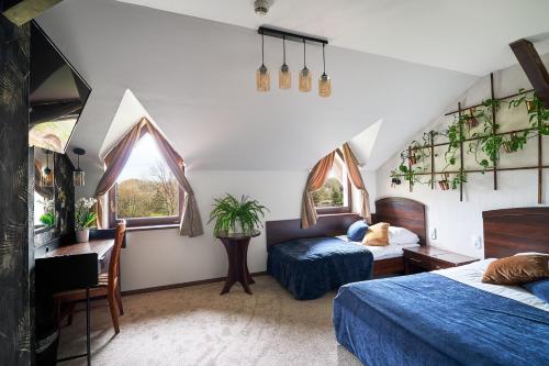 Owińska茉莉酒店 的一间卧室设有两张床、一张桌子和窗户。