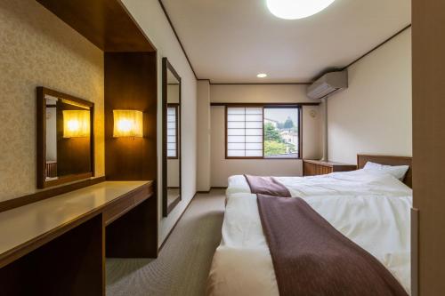高山Hirayukan的一间卧室配有一张大床和镜子