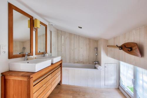 阿尔桑雷Adresse privilegiee a Ars-en-Re的浴室配有盥洗盆和浴缸。