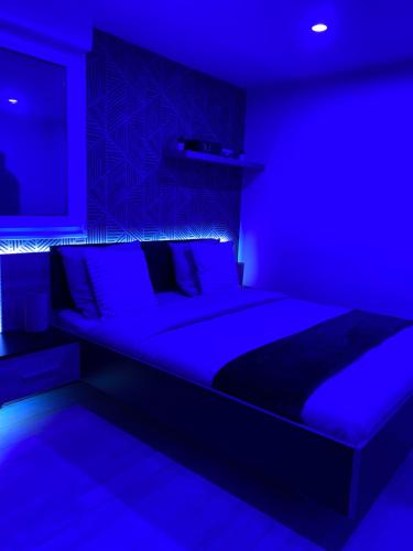 弗朗斯地区特朗布莱Atelier chaleureux - CDG的蓝色卧室配有一张蓝色灯光大床