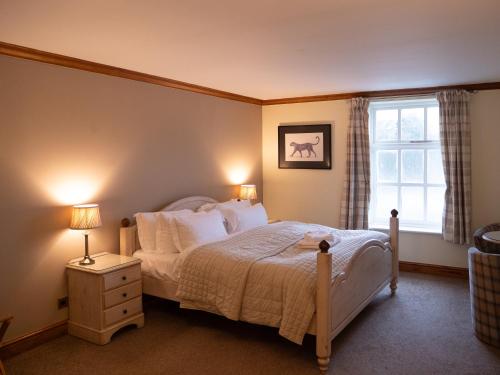 奇切斯特维斯特瑞酒店的一间卧室配有一张带白色床单的床和一扇窗户。