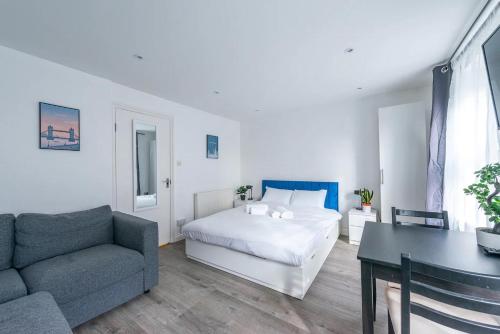 伦敦Pass the Keys Kings Cross City Escape的一间卧室配有一张床、一张沙发和一张桌子