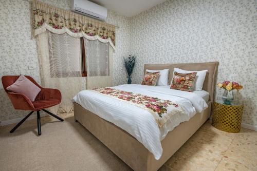 Yarkaוילה ריש - מושלמת למשפחות עם בריכה, ג'קוזי ונוף的卧室配有床、椅子和窗户。