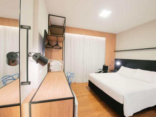 库里提巴库里提巴购物宜必思酒店的一间卧室配有一张床、一张桌子和一张床,一间房间