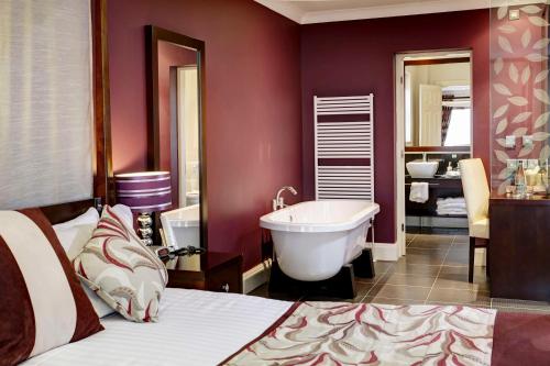 皮克林Best Western Forest and Vale Hotel的一间带一张床和浴缸的卧室以及一间浴室