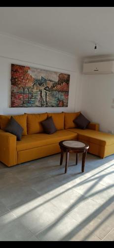 沙姆沙伊赫sea street hadaba的客厅配有黄色的沙发和桌子