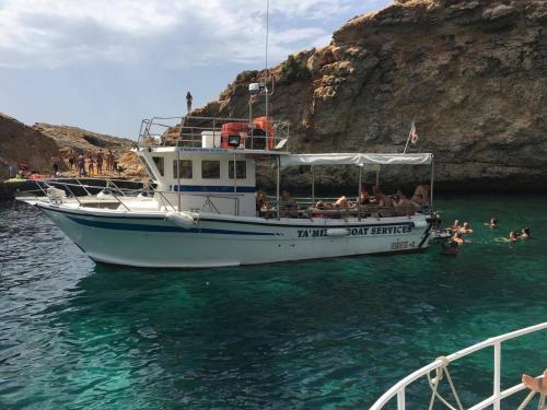 艾因西莱姆Comino Gozo Private Boat Trips Charters的船上的人在水中