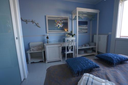 加里波第港B&B Sogno D'Estate的蓝色卧室配有一张床和一张书桌