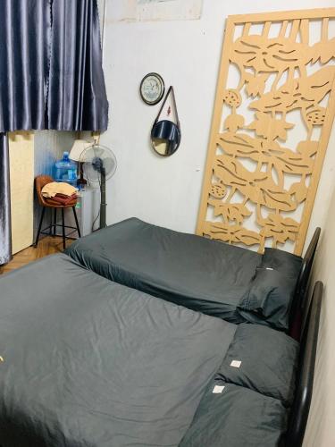 河内Head of Quarter -TRIPLE BED ROOM- CHEAP的卧室配有一张床,墙上挂着一个钟