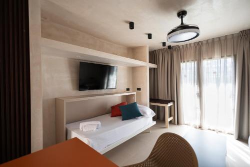 美洲海滩普拉亚祖尔公寓的卧室配有一张床,墙上配有电视。