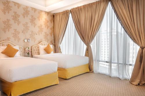 多哈多哈广场酒店的一间卧室设有两张床和大窗户
